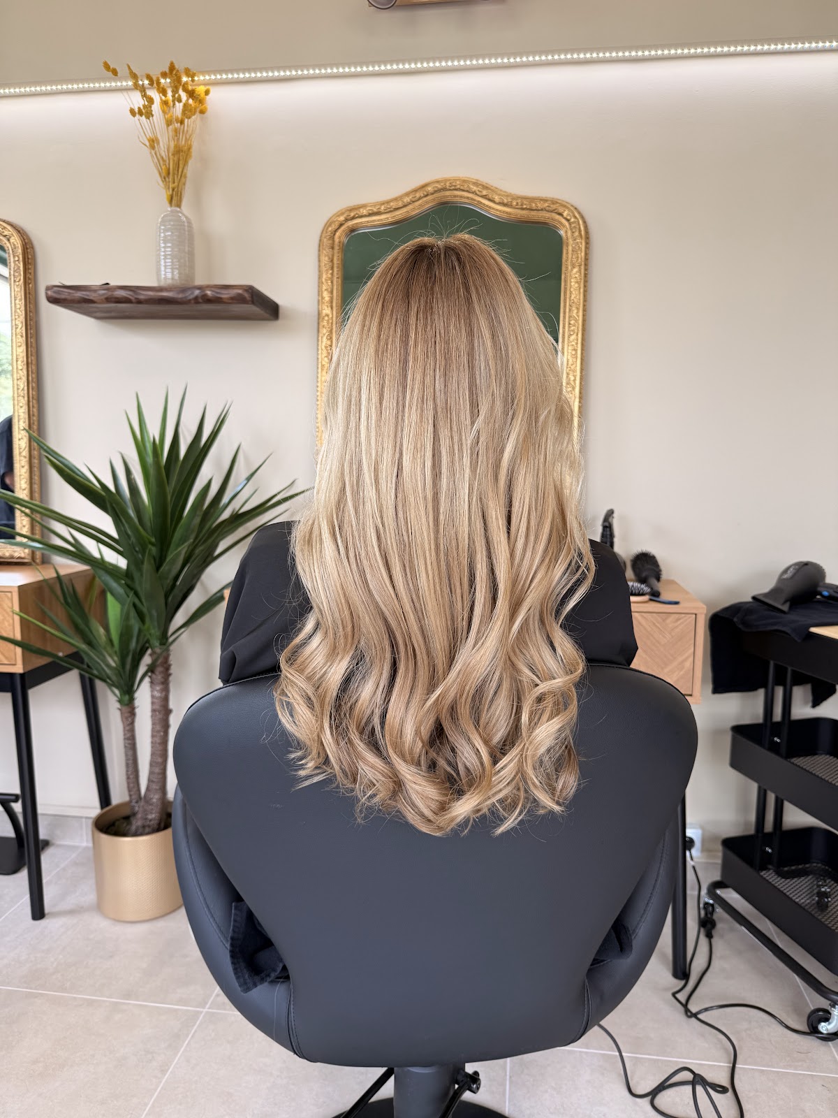 Close-up of long blonde wavy hair styled at a salon chair