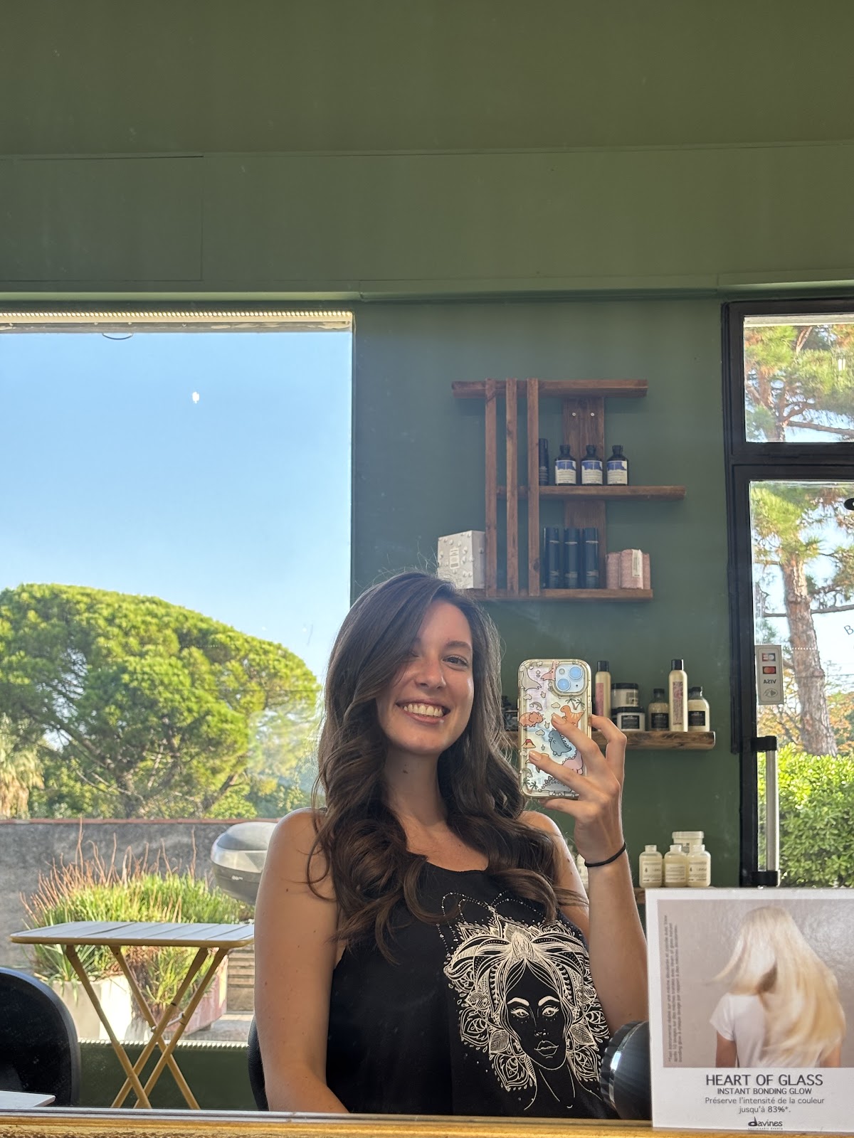 Client at the salon reception, green walls and shelves in view