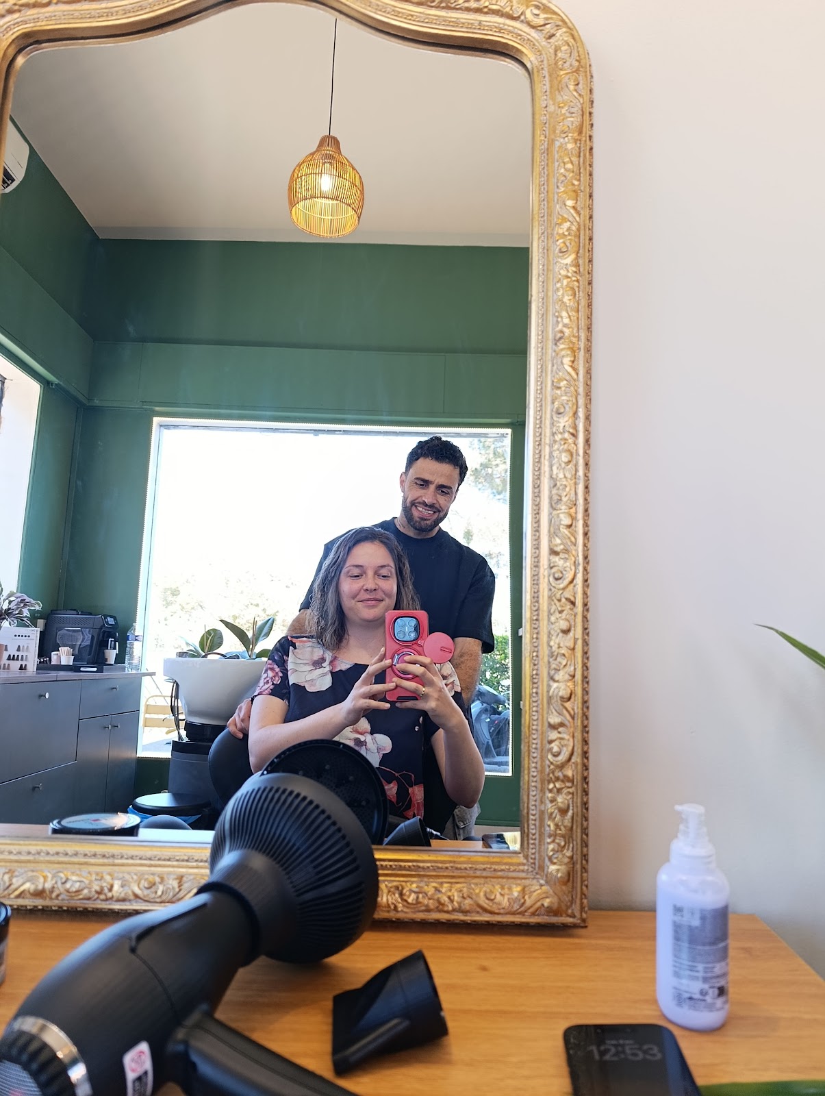 Clients reflected in the salon mirror, green walls in the background